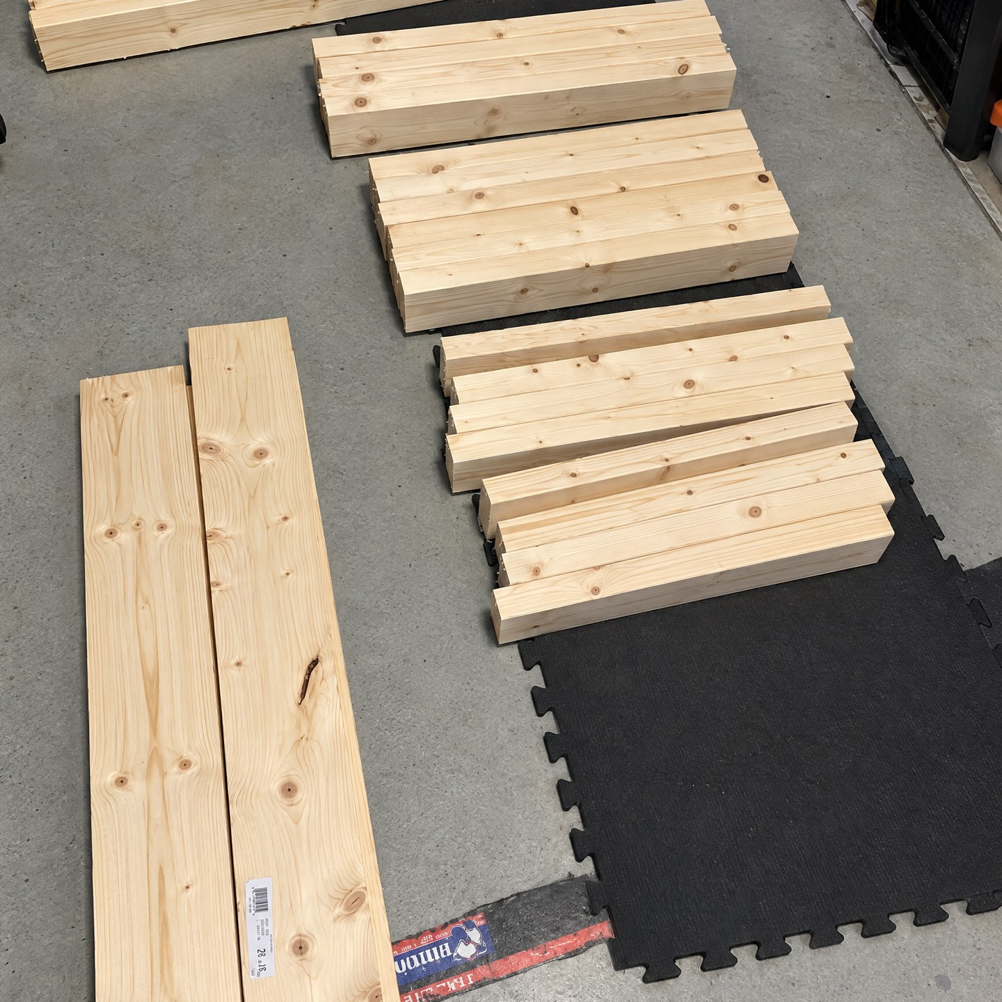 Cut boards sorted by length on the garage floor