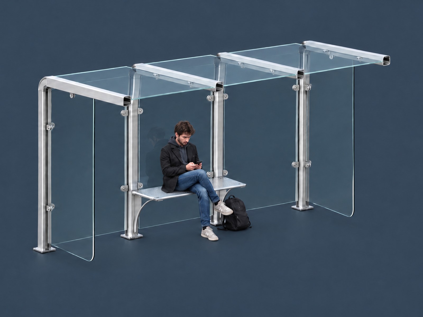 Bus shelter with an aluminium frame, glass back, roof and side panels, with someone sitting on the seat between the two middle posts